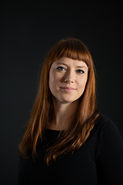 Photograph of K.R. Gaddy, the author. Woman with red hair and a black shirt smiling.