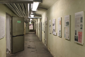 Photograph of the hallway of the women's prison at Brauweiler, currently a museum with posters on the wall.